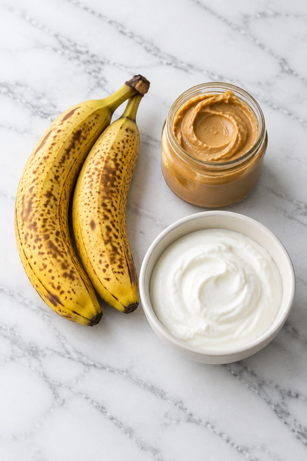 Ingredients for frozen peanut butter banana dog treats: two ripe bananas, natural peanut butter and plain Greek yogurt.